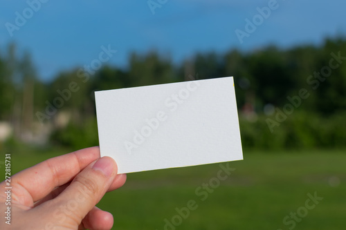 empty business card in hand on nature background