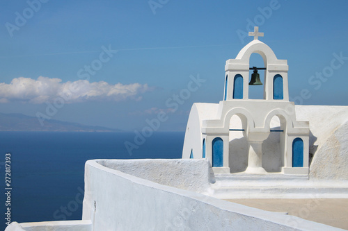 Beautiful blue and white small traditional greek ortodox church by the sea on Santorini island, Oia, Thira. Delicate bell tower.