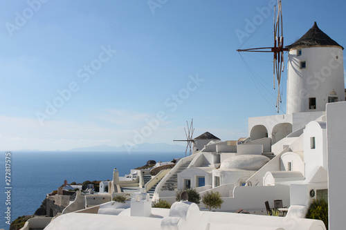 Santorini oia fira caldera classic view in the middle of the sunny day. Traditional greek white houses and windmills.