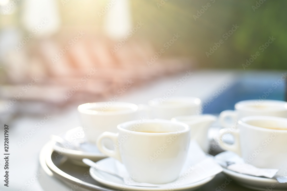White coffee cups on the pool table. Very bright summer light photo with soft focus.