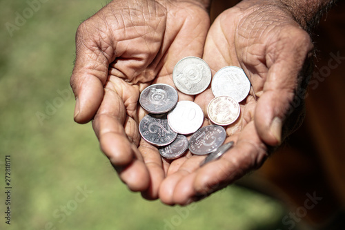 Coins in dark working hands. Beyond the poverty line in Asian countries. Subject soap bar.