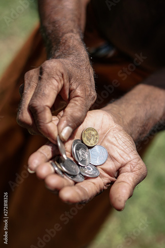 Coins in dark working hands. Beyond the poverty line in Asian countries. Subject soap bar.