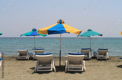 Three umbrellas and six sun beds on a beach