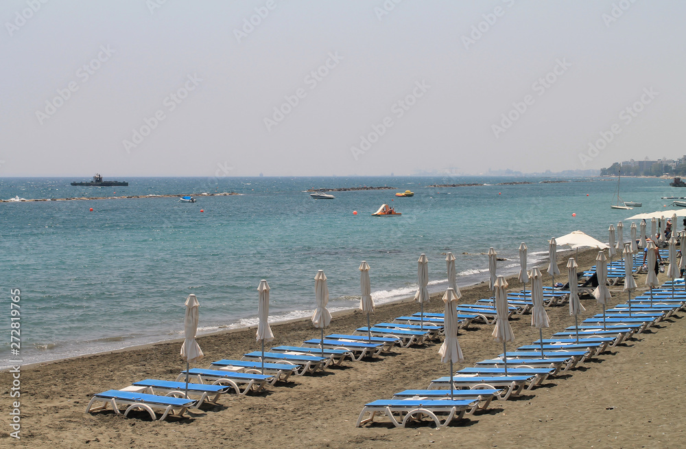 Fototapeta premium Sandy beach with sun beds and umbrellas