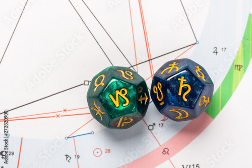 Astrology Dice with zodiac symbol of Capricorn Dec 22 - Jan 19 and its ruling planet Saturn on Natal Chart Background photo