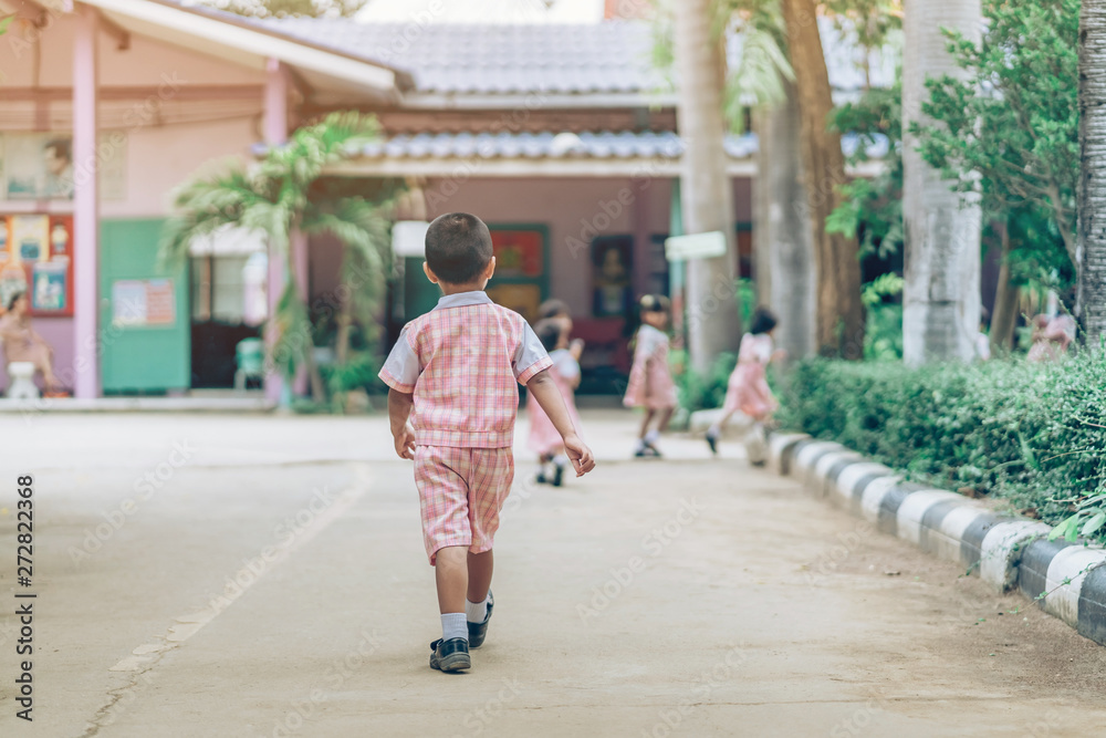 Back view of Boy followed girl friends on street to go to the classroom in school.