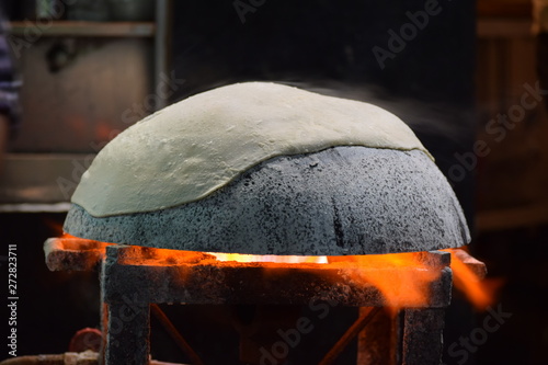 Preparing tandoori roti on tawa in a traditional way
