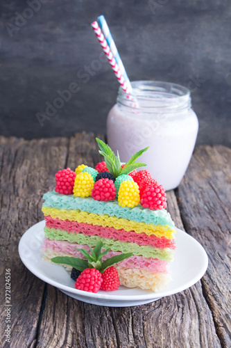 Colorful waffle cake with raspberries and a glass of milkshake