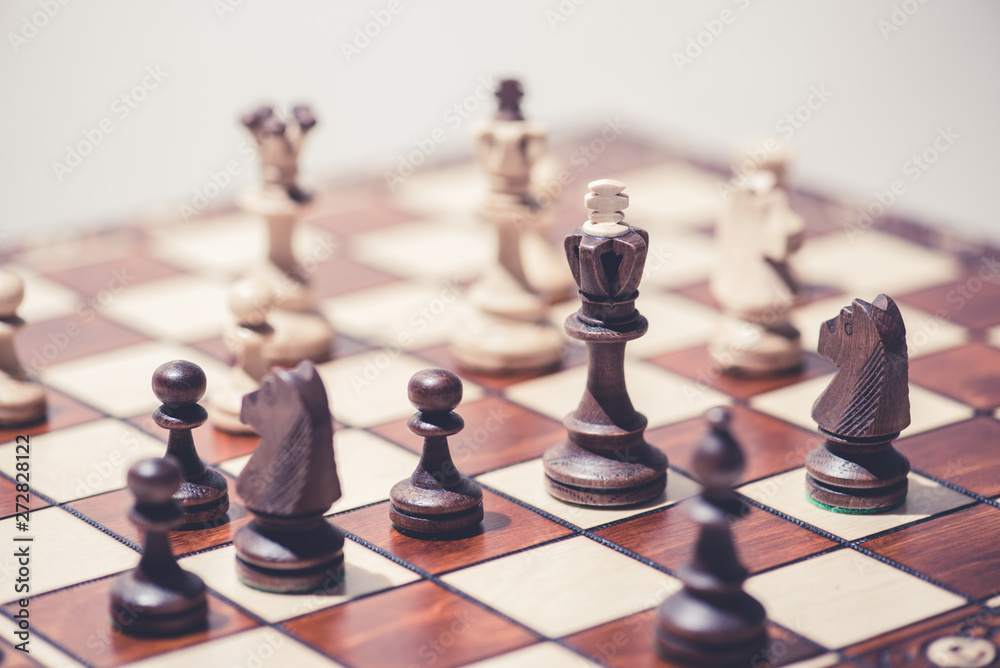 black against white chess pieces on chess board black against white chess pieces on chess board