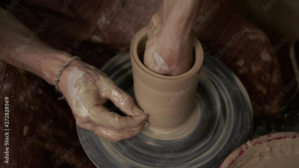 The potter makes a jug of clay. Ceramist. A man makes a vase on a potter's wheel. Hands of the master turn a piece of clay into a jug. Handwork. Pottery. Sculptor's wet hands close up. Clay dishes The potter makes a jug of clay. Ceramist. A man makes a vase on a potter's wheel. Hands of the master turn a piece of clay into a jug. Handwork. Pottery. Sculptor's wet hands close up. Clay dishes