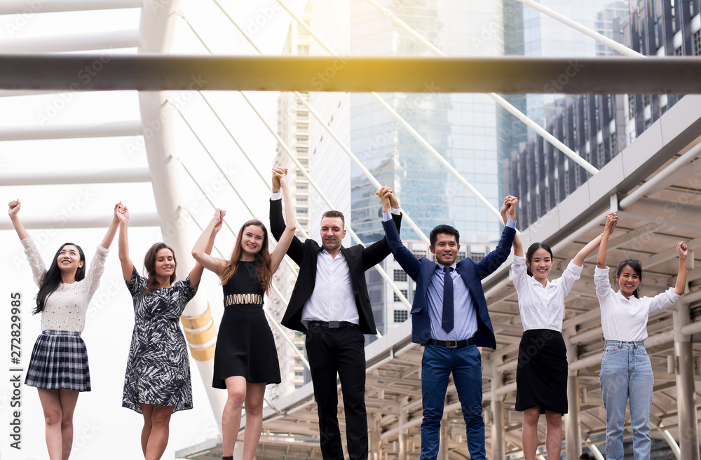 Fototapeta premium Mergers and acquisition,Successful group of business diversity people,Team success achievement hand raised up at outdoor