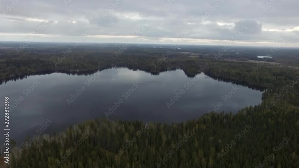 Aerial drone shot of forest and fields. Flying over Finland landscape. Cloudy day. Mirror surface lake water. Aerial drone shot of forest and fields. Flying over Finland landscape. Cloudy day. Mirror surface lake water.