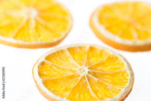 Three dried orange slices isolated on white background - selective focus