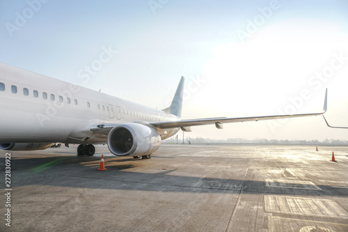 Passenger aircraft at the airport near the terminal. Unloading and loading baggage. Stock photo