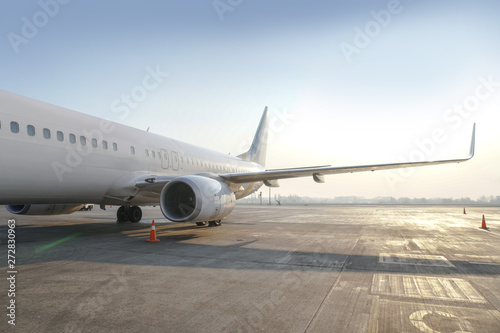 Passenger aircraft at the airport near the terminal. Unloading and loading baggage. Stock photo