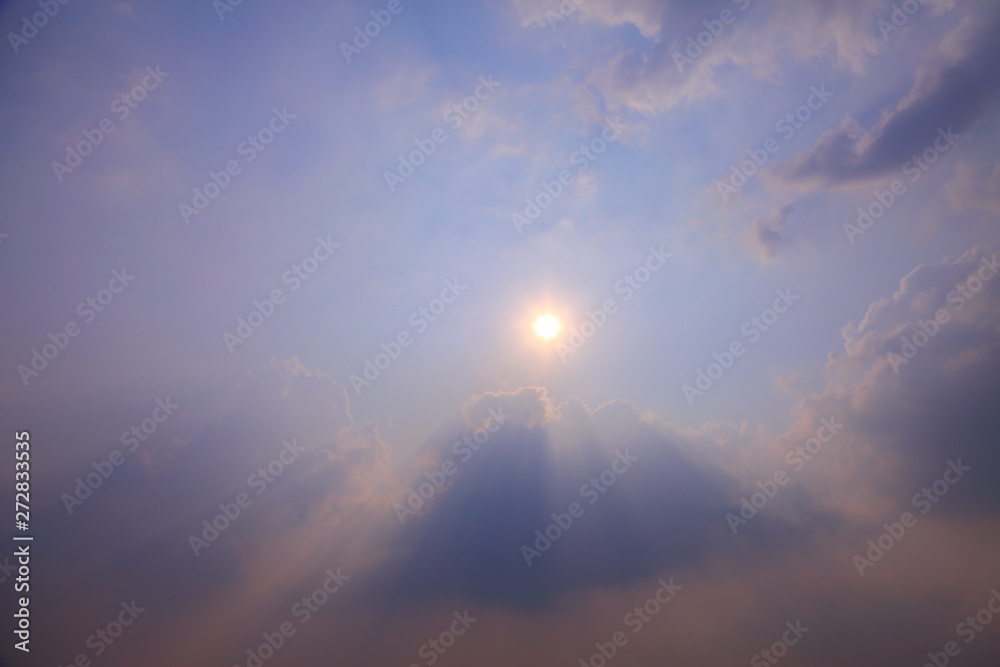 Beautiful crepuscular ray of sunlight shines through the cloud with copy space for background design purpose