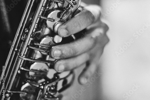 Black and white arty closeup picture of hands of a man playing saxophone