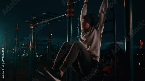 Guy doing abs workout outdoor at nighttime.