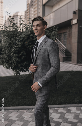 Businessman in full suit posing in cityscape. Stylish young handsome man model. Success lifestyle. Business concept. Street style