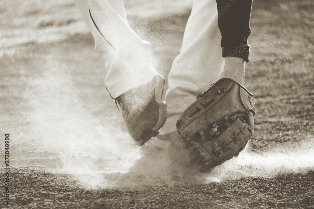 Baseball player fielding grounder ball in field dirt, action shot with vintage sports style.