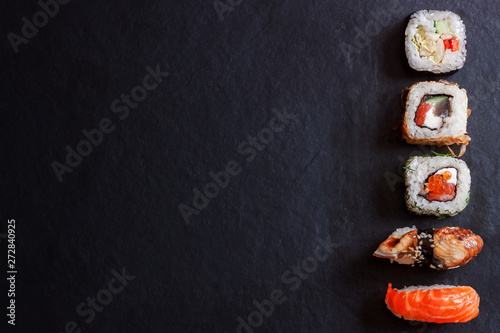 Top view traditional japanese sashimi sushi on black board background copy space