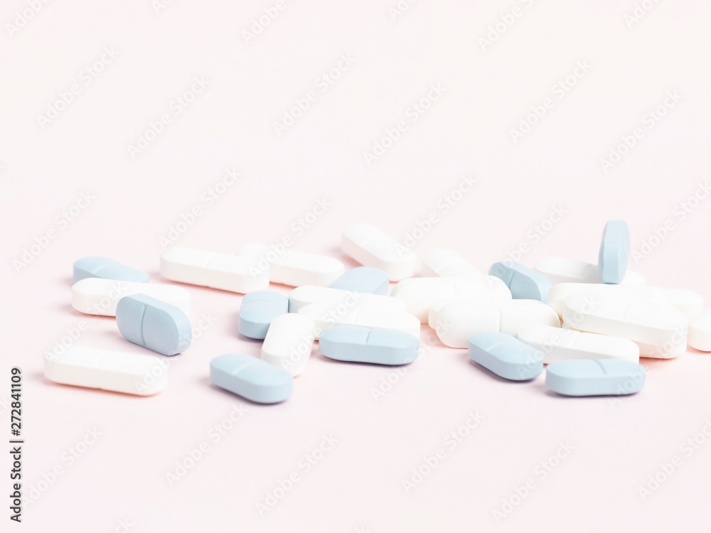 White and blue tablets on a white, highly contrasting background