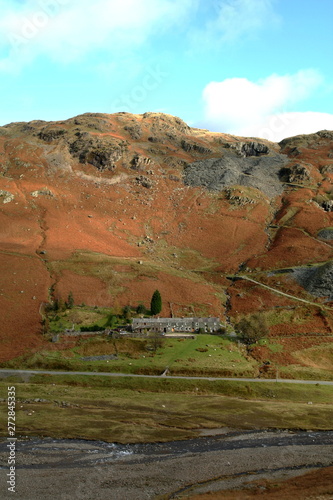 Lakeland mountain side near Coniston Cumbria. Old abandoned mineworkings near the mountain top and miners cottages dwarfed at the bottom. photo