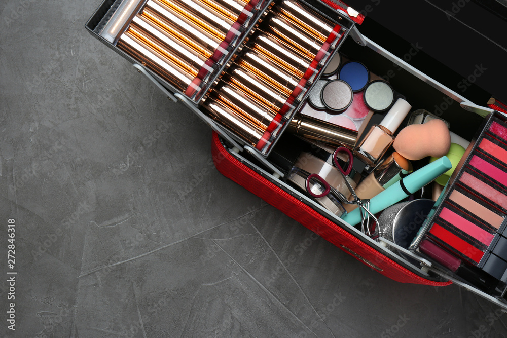 Naklejka premium Set of different professional makeup products in case on table, top view. Space for text