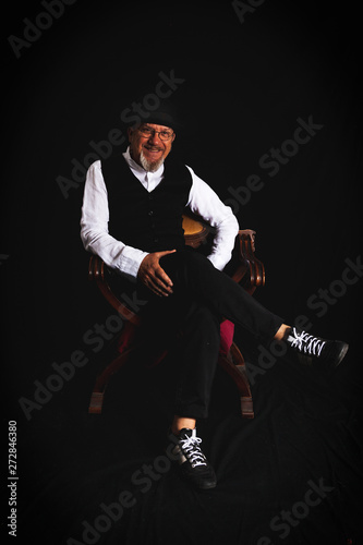 portrait of white bearded hipster man sitting in a photo studio