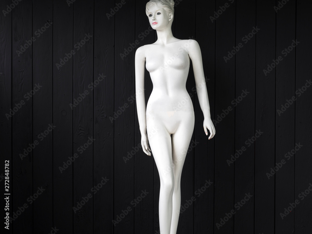 white mannequin for clothes on a black wooden background white mannequin for clothes on a black wooden background