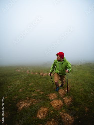 Young man with headlamp hiking through the fog