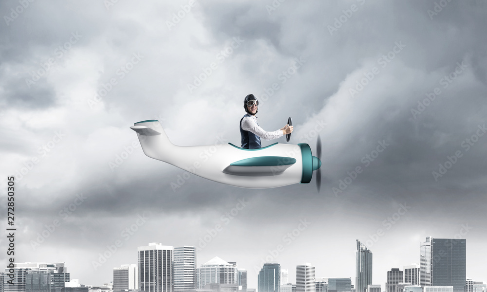 Businessman in aviator hat driving paper plane