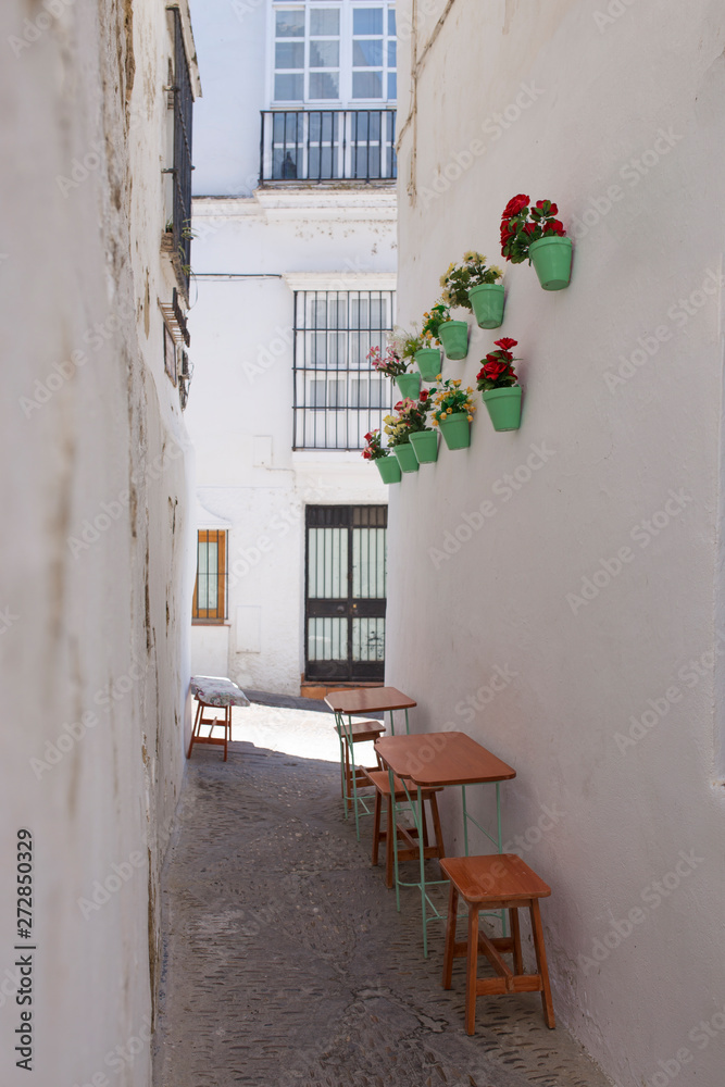 Fototapeta premium White village Arcos de la Frontera, Cadiz, Andalusia, Spain. Little restaurant terrace at narrow street