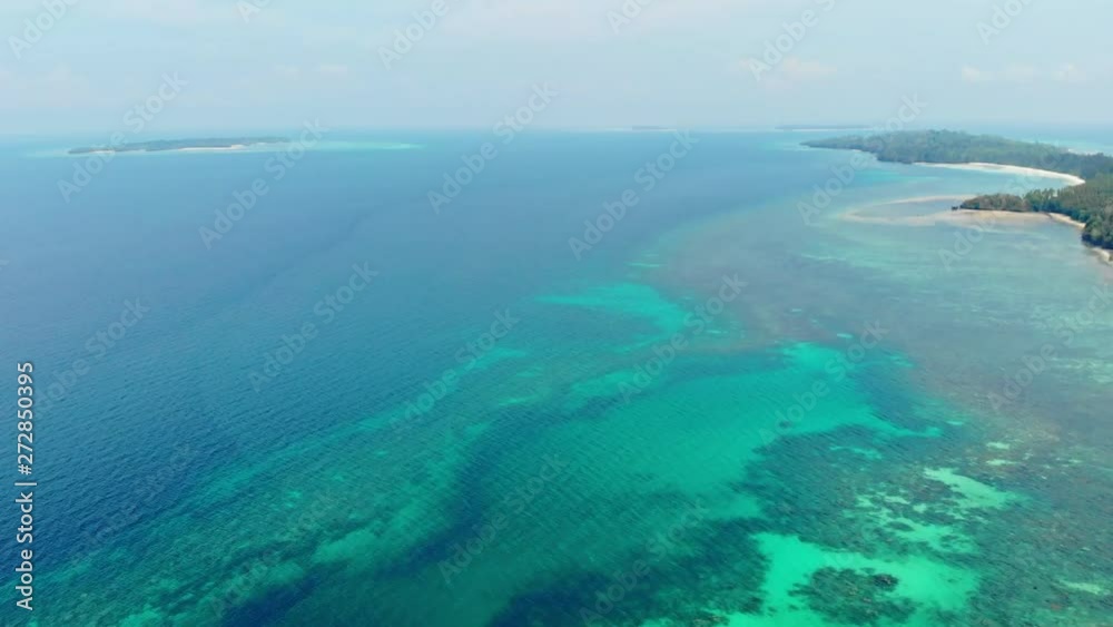 Aerial: uncontaminated coastline tropical beach caribbean sea coral reef atoll in the Kei Islands Maluku Indonesia scenic travel destination natural ecosystem marine life
