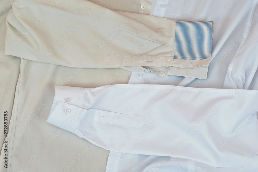 Clean and dirty shirt together. Two white shirts in one shot. The concept of washing and bleaching clothes. The contrast between the new and the old shirt.