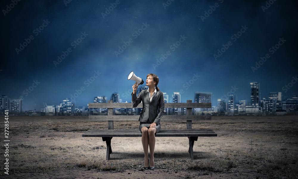 Business woman with megaphone on wooden bench Business woman with megaphone on wooden bench