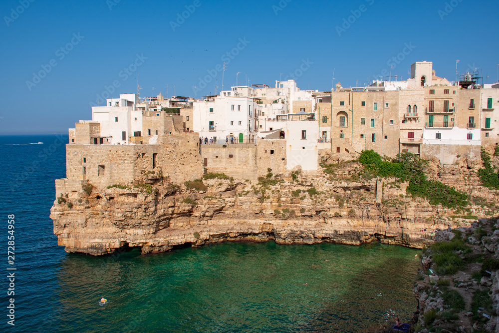 Panoramic city skyline with white houses of Polignano a Mare, town on the rocks, Puglia region, Italy, Europe. Traveling concept background with blue Mediterranean sea