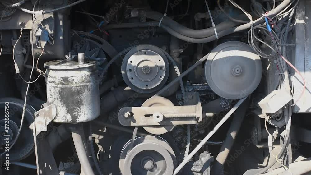 Timing belt alternator belt in motion on a running car engine. Car