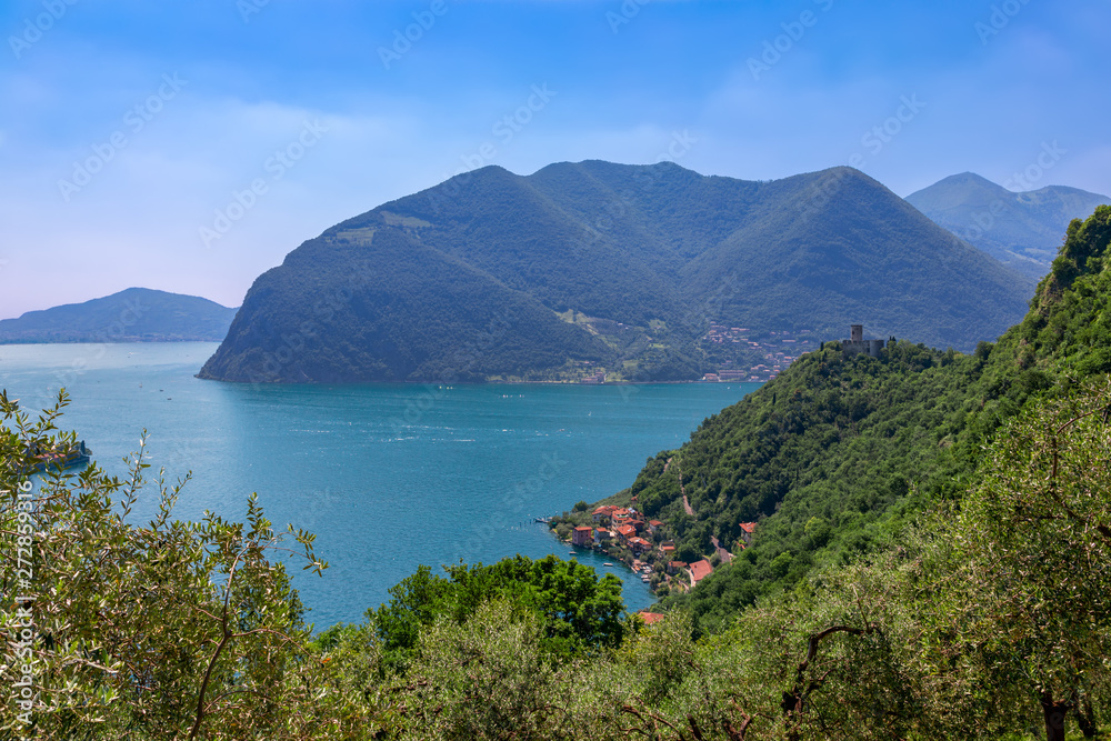 Beautiful view of Lake Iseo with a small old town on the shore and a medieval castle on the hill.