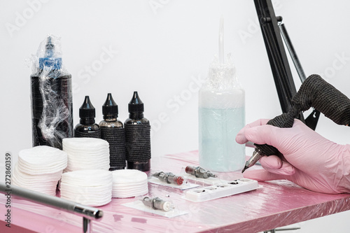 Close up of tattoo master tools. Needles, inks, petroleum jelly and disinfectant liquid. photo