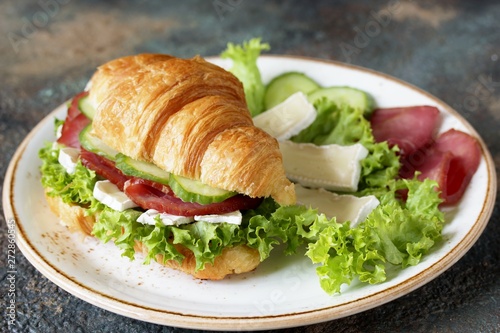 croissant sandwich and tea. breakfast in French. jerky, camembert ch