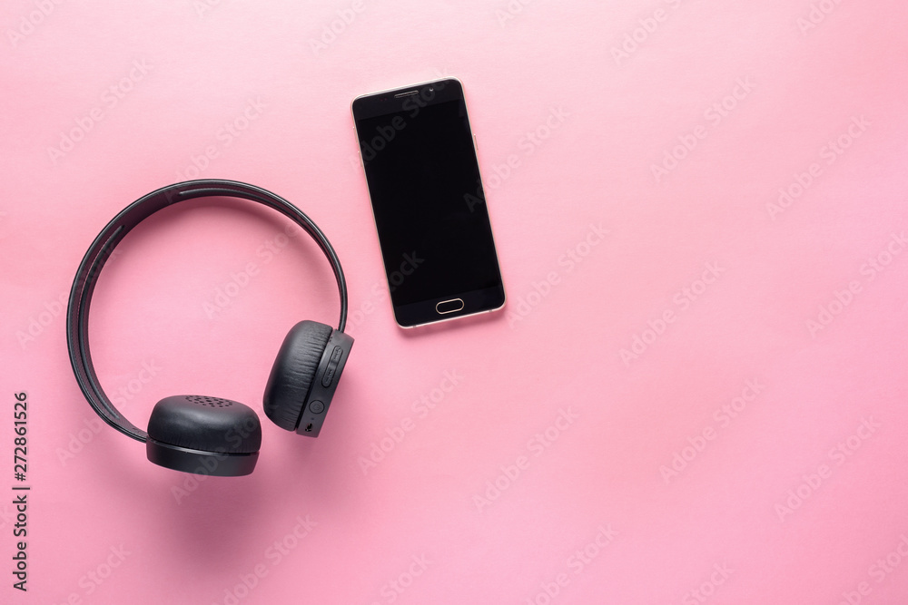 concept of gadgets for music lovers. wireless headphones and smartphone on pink background with copy space concept of gadgets for music lovers. wireless headphones and smartphone on pink background with copy space