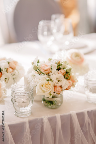 Wedding in the style vintage. Decoration of the table with flowers and cutlery. Composition from flowers. Elegant dining table in peach-purple color. Indoors wedding reception venue with festive decor © Anastasia