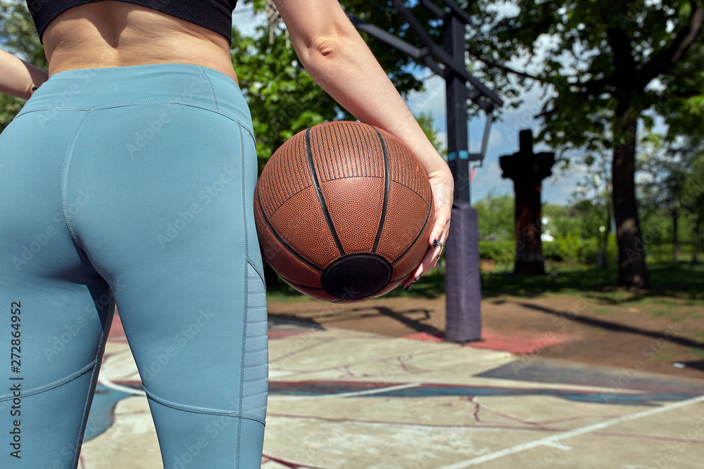 Beautiful sexy fitness girl in black sport wear with perfect body with basket ball at basketball court. Sport, fitness, lifestyle concept Beautiful sexy fitness girl in black sport wear with perfect body with basket ball at basketball court. Sport, fitness, lifestyle concept