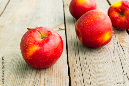 Ripe red apples on a wooden table. Rustic style, close-up