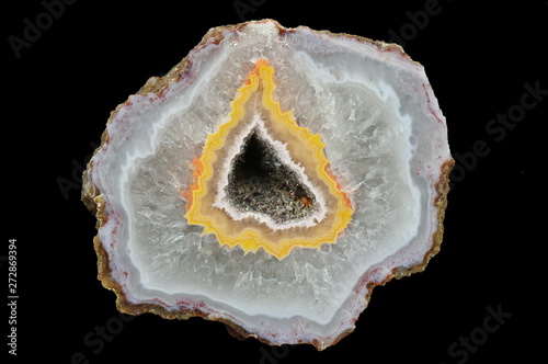 A cross-section of agate. Filled with quartz. In the center silica ring coloured by metal oxides and geode.