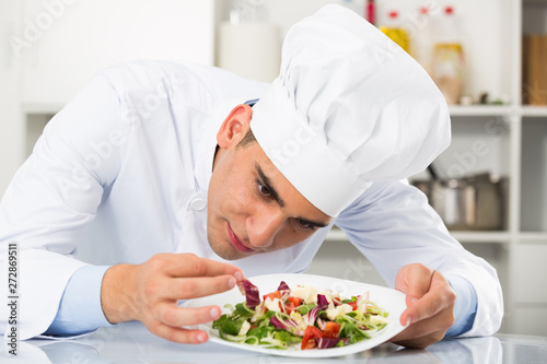 Chef is evaluating prepared dish