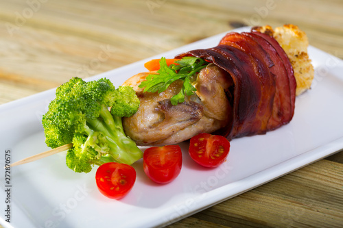 Grilled quail with jamon on skewer with vegetables