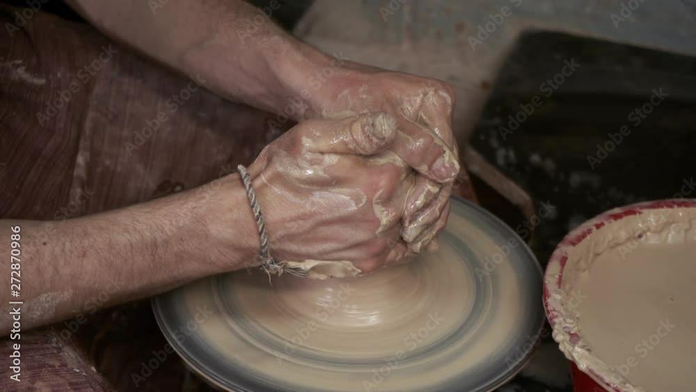 The potter makes a jug of clay. Ceramist. A man makes a vase on a potter's wheel. Hands of the master turn a piece of clay into a jug. Handwork. Pottery. Sculptor's wet hands close up. Clay dishes The potter makes a jug of clay. Ceramist. A man makes a vase on a potter's wheel. Hands of the master turn a piece of clay into a jug. Handwork. Pottery. Sculptor's wet hands close up. Clay dishes
