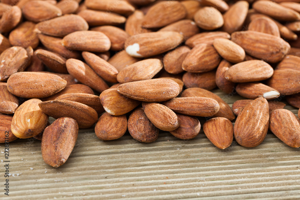 Obraz premium Roasted almonds on wooden table